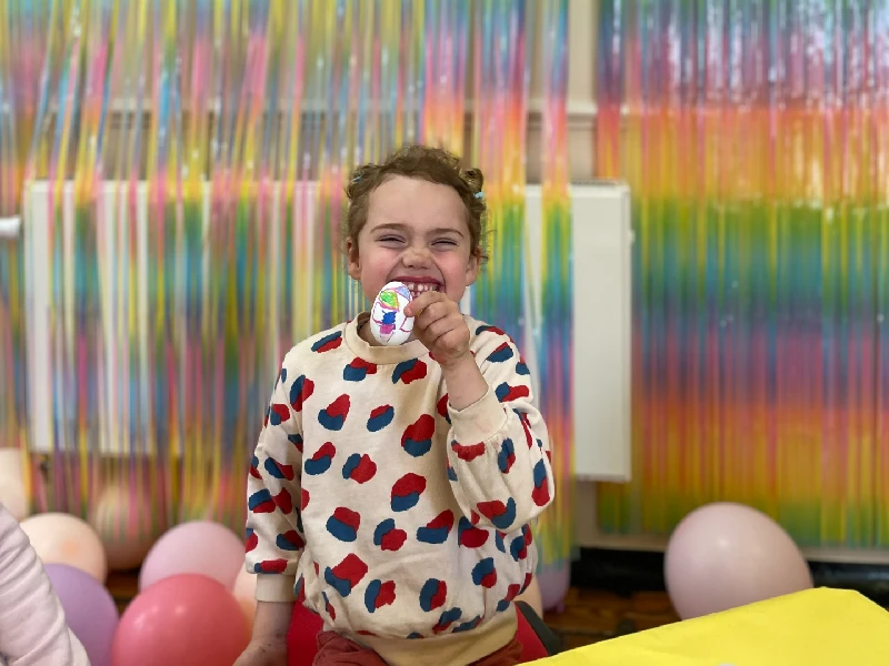 A child holding up her painted easter egg